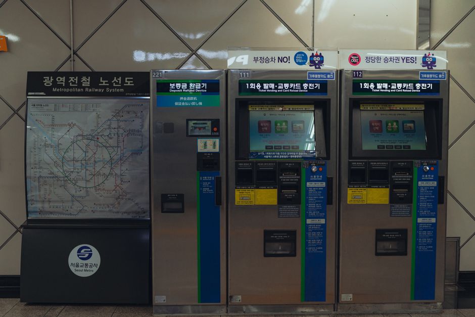 Ticket vending machines and map at a Seoul Metro station, showcasing urban transit in South Korea.